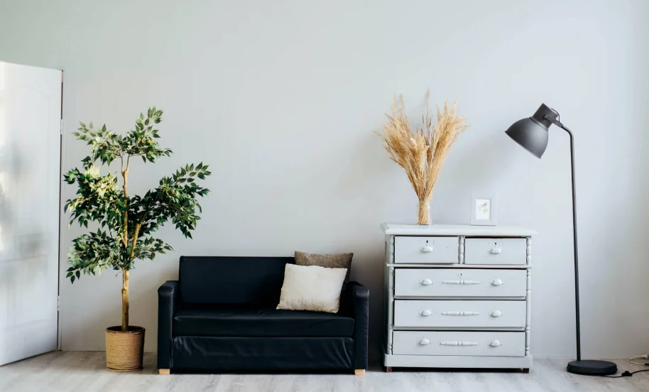 A black couch in a grey room.