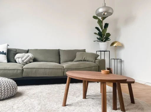 A stylish olive couch with a wooden table